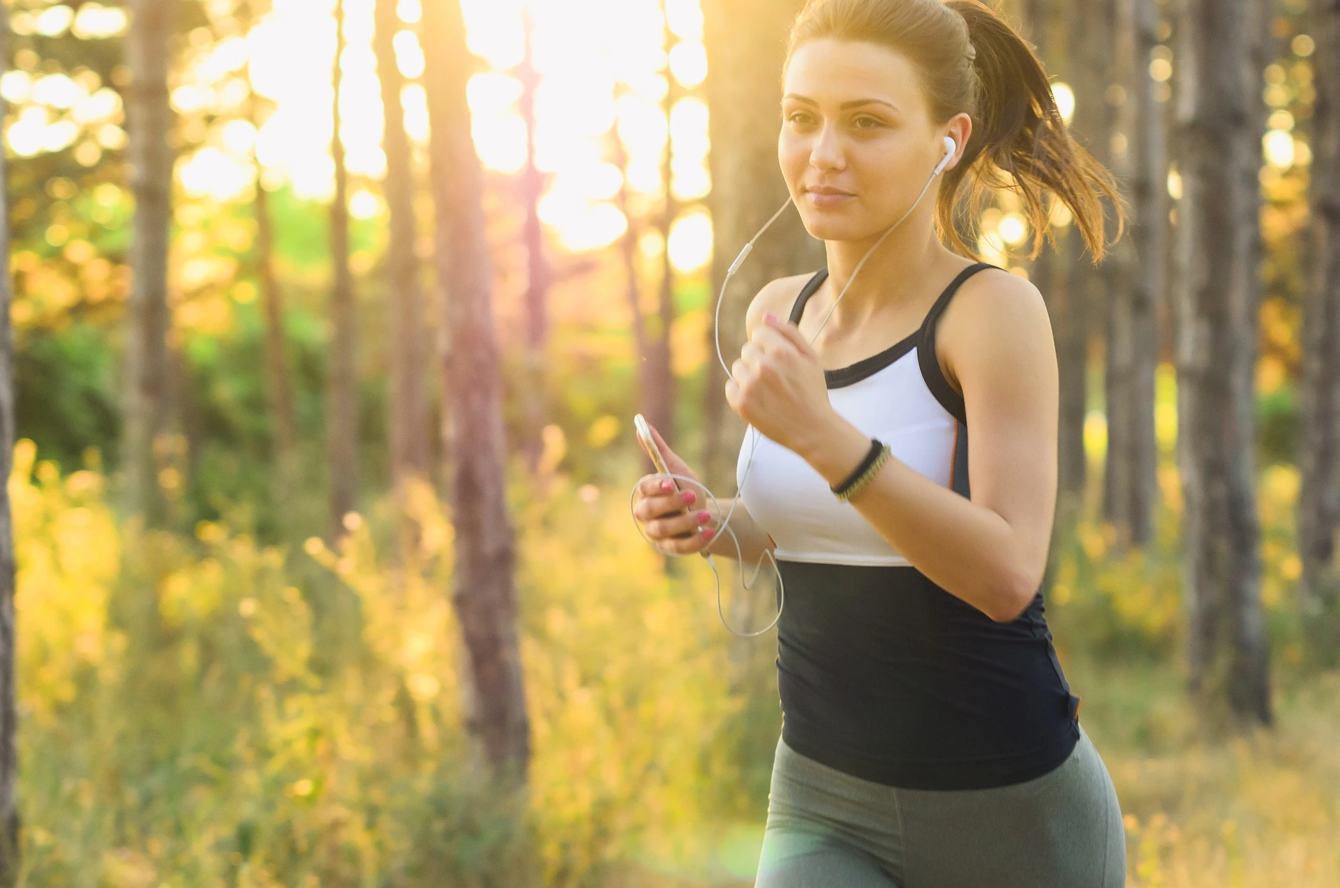 Mujer corriendo en un campo soleado